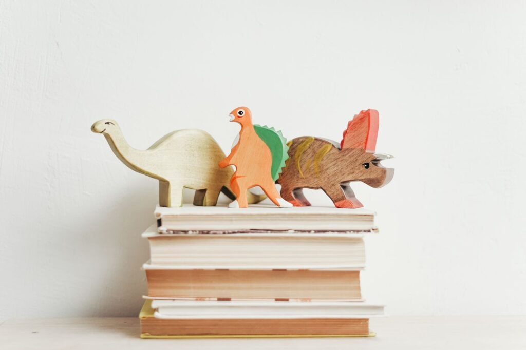 Livres pour enfants empilés avec des figurines de dinosaures en bois